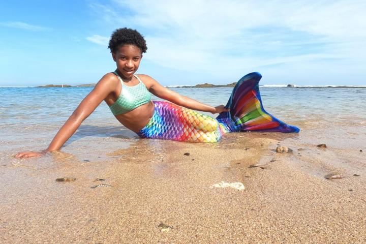 a little boy that is standing in the sand on a beach